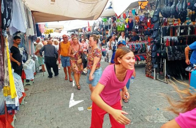 Turistik pazarlarda turistlerin koluna boncuktan yapılma bilekleri takarak 2 Euro istemesi turistleri bezdirdi...